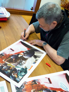 Alberto nel suo studio mentre autografa le sue opere