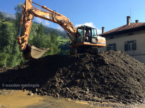 Cumuli di terra rimossa dalla strada grazie ad una ruspa ancora a lavoro