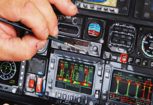 La mano ferma e sicura di Ercole Furia mentre rifinisce i dettagli della strumentazione di un cockpit aeronautico