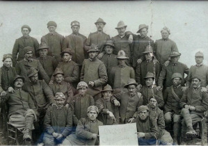 Una foto storica dove 29 Mascabroni, il reparto di indomiti Alpini del capitano Sala, posa davanti ad un cartello che li ricorda come i reduci della Cma Undici e del passo della Sentinella